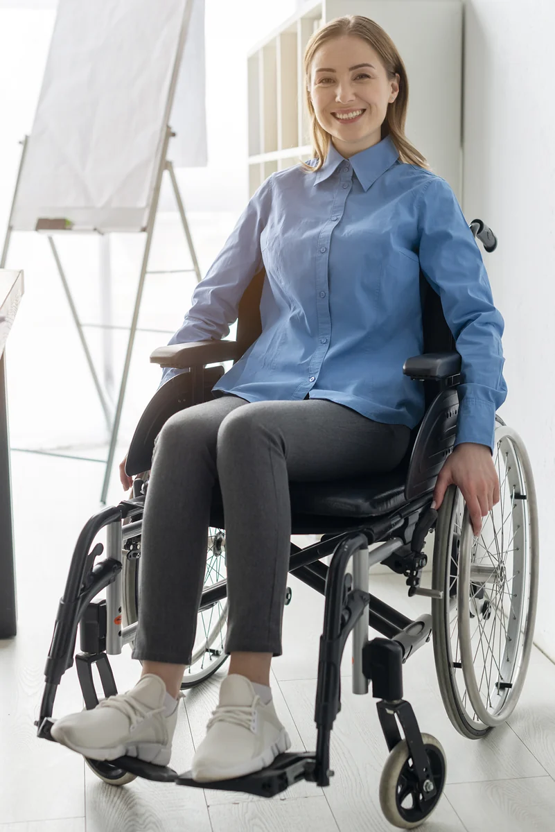 Mulher de camisa azul sorridente sentada em cadeira de rodas manual — cadeira de rodas registro Anvisa