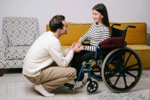 Mulher em cadeira de rodas manual com acompanhante em ambiente interno representando conforto e escolha da cadeira de rodas ideal
